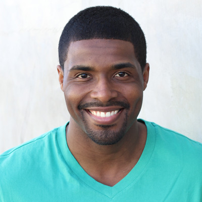 An elderly couple sharing a warm embrace with smiles on their faces.