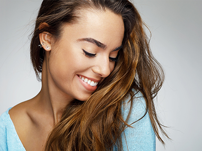 A young woman with long hair smiles at the camera.